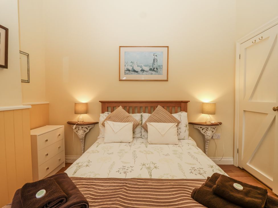 A bedroom with a bed and bedside tables at Flagstaff Cottage
