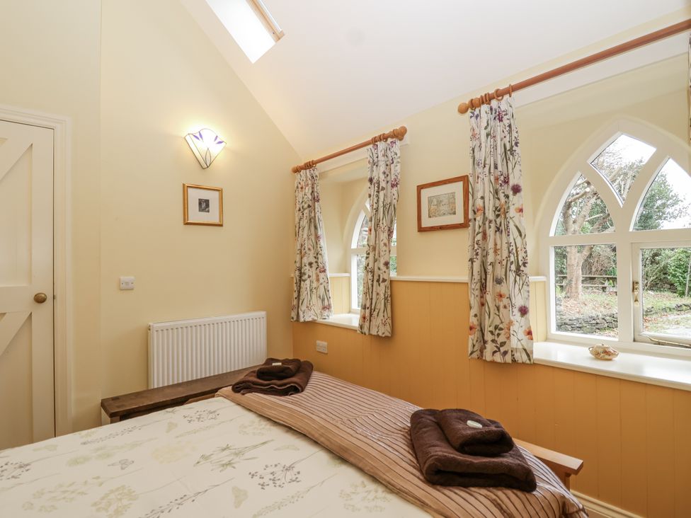 A bedroom with a bed and window at Flagstaff Cottage