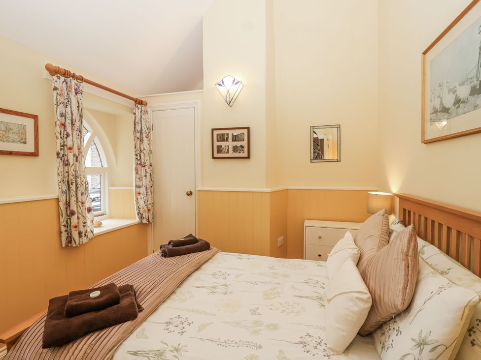 A bedroom with a bed and window at Flagstaff Cottage