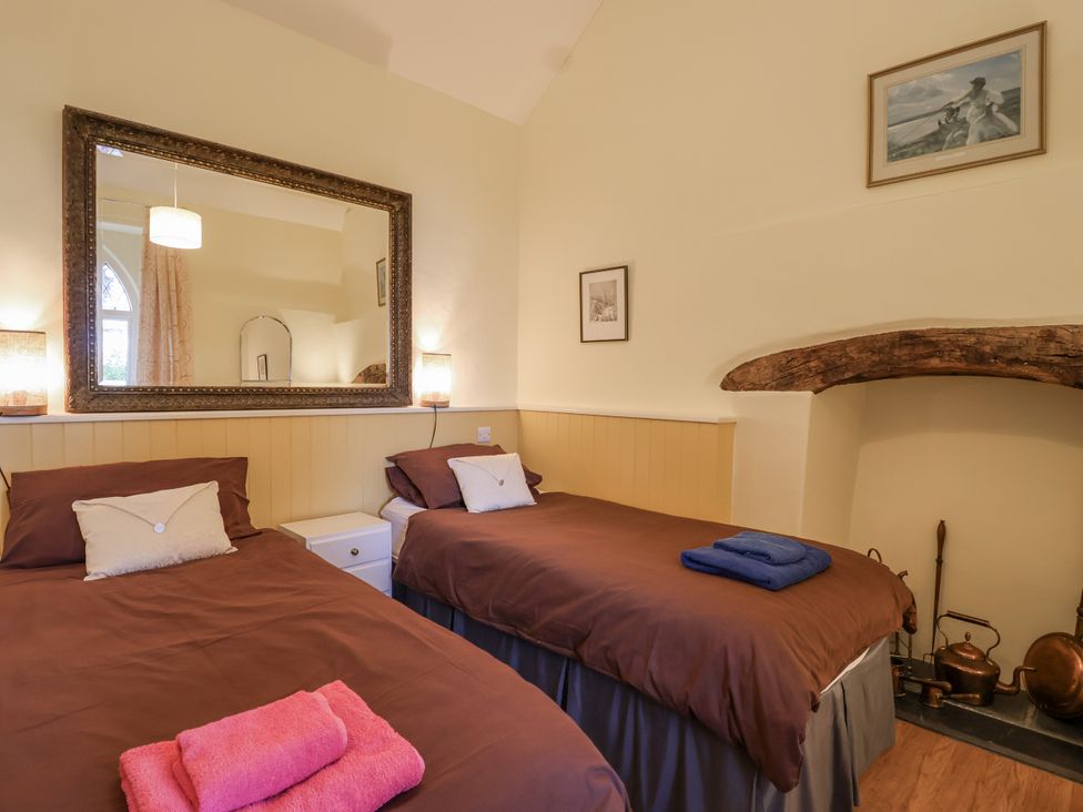 A bedroom with two beds and a fireplace at Flagstaff Cottage 