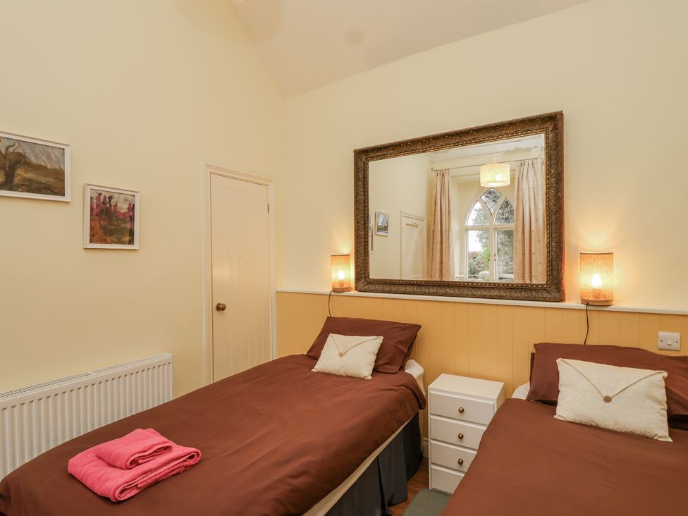A bedroom with twin beds and a mirror at Flagstaff Cottage 
