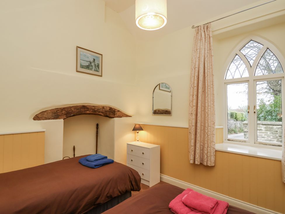 A bedroom with twin beds and a window at Flagstaff Cottage