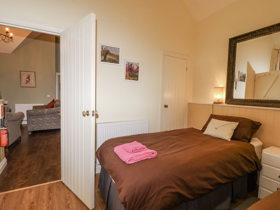 A bedroom with a bed and a table at Flagstaff Cottage