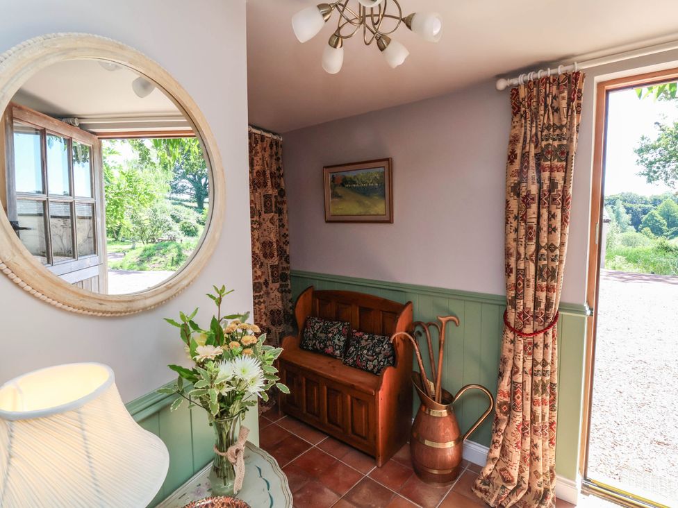 An entryway with a couch and decorative items at Captains Barn in Tiverton