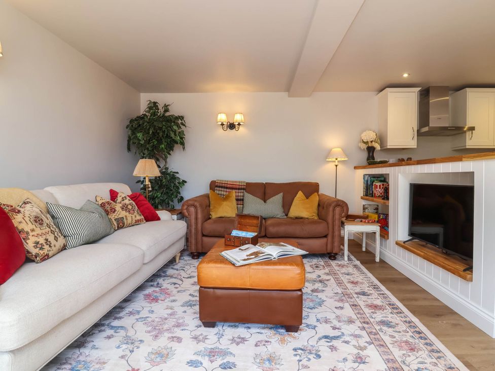 A living room with a sofa and armchair at Captains Barn in Tiverton