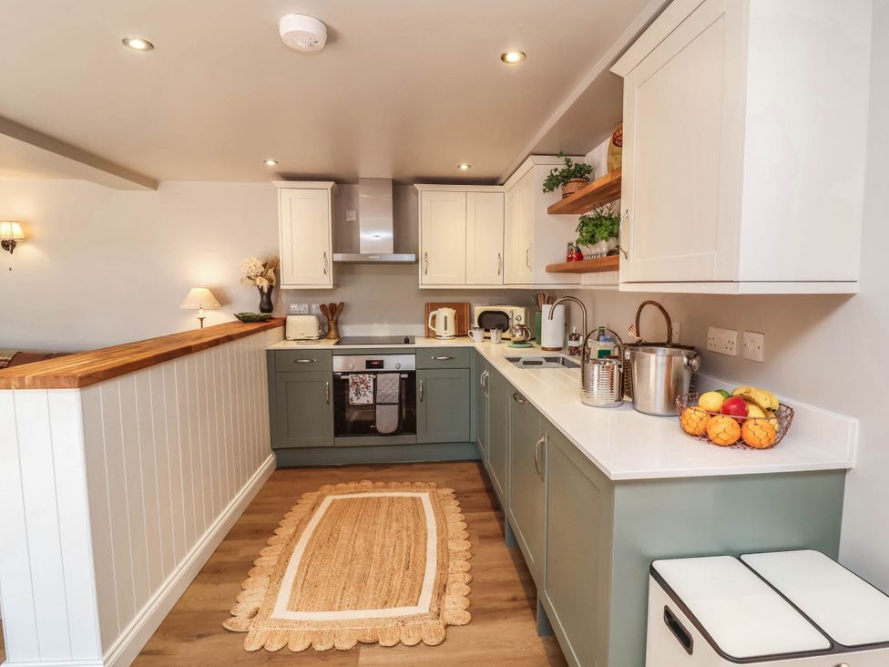 A kitchen with cabinets and appliances at Captains Barn in Tiverton
