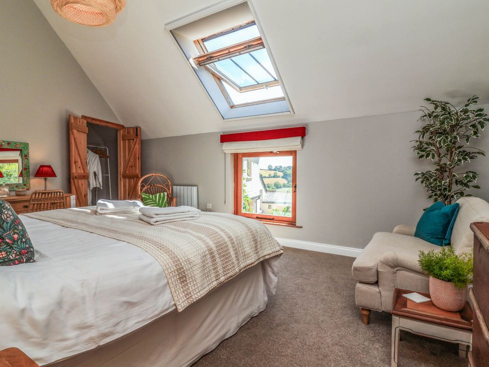 A bedroom with a bed and window at Captains Barn Tiverton