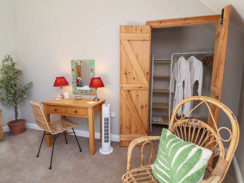 A bedroom with a desk, chair, and wardrobe at Captains Barn Tiverton