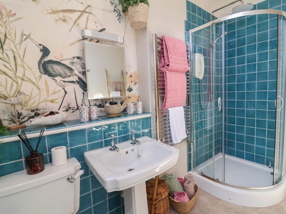 A bathroom with a sink, toilet, and shower at Captains Barn in Tiverton