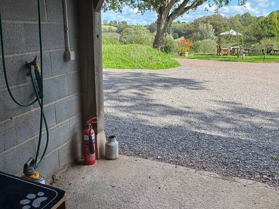 A garage with a hose and fire extinguisher at Captains Barn in Cadeleigh near Tiverton