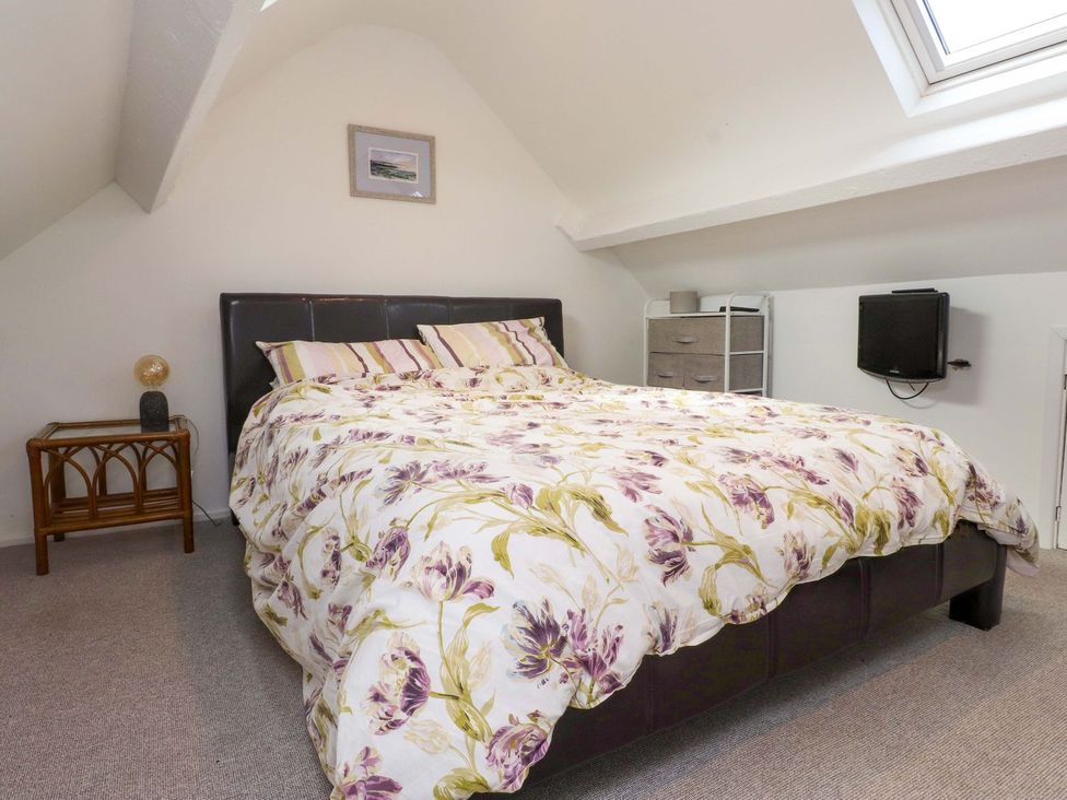 A bedroom with a bed and a bedside table at Bodefi in Pwllheli