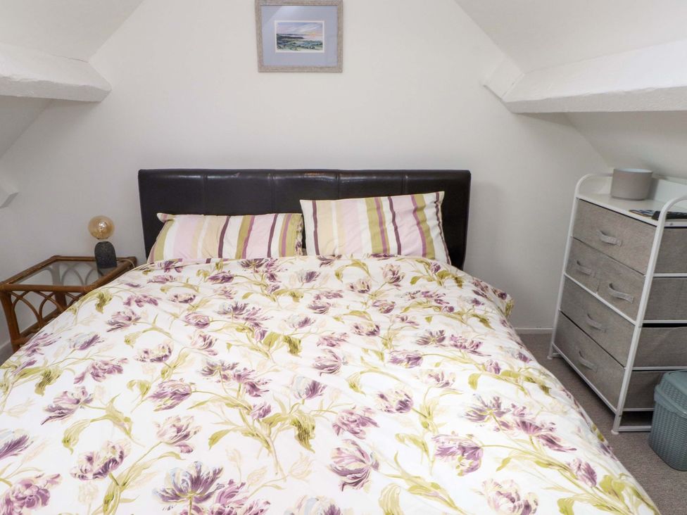A bedroom with a bed and bedside table at Bodefi in Pwllheli