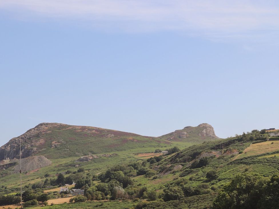 A view of hills and mountains with greenery and blue sky at Bodefi in Pwllheli