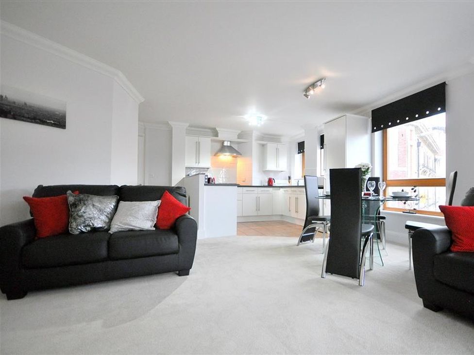 A living room with a sofa and dining area at Old Harbour View in Weymouth