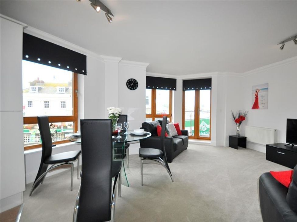 A living room with a table and chairs at Old Harbour View in Weymouth