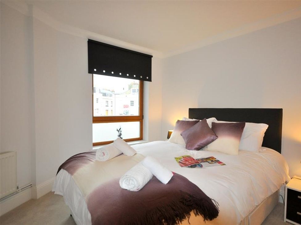 A bedroom with a bed and window at Old Harbour View in Weymouth