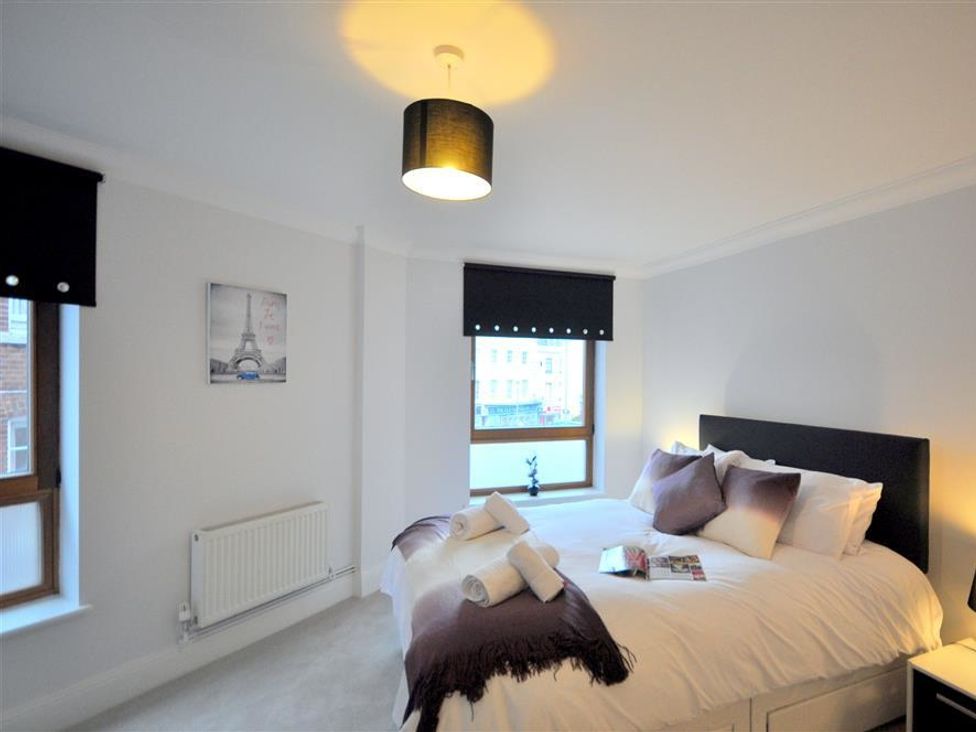 A bedroom with a bed and window at Old Harbour View in Weymouth