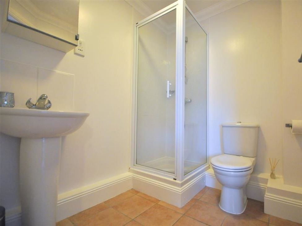 A bathroom with a shower, toilet, and sink at Old Harbour View in Weymouth