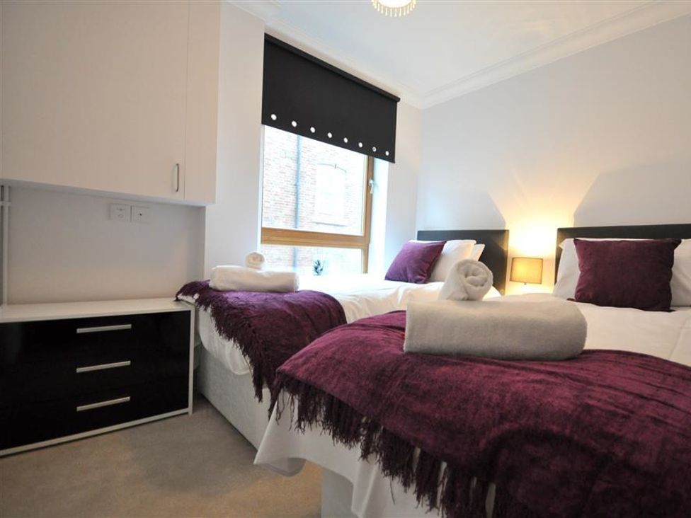 A bedroom with twin beds and a window at Old Harbour View in Weymouth