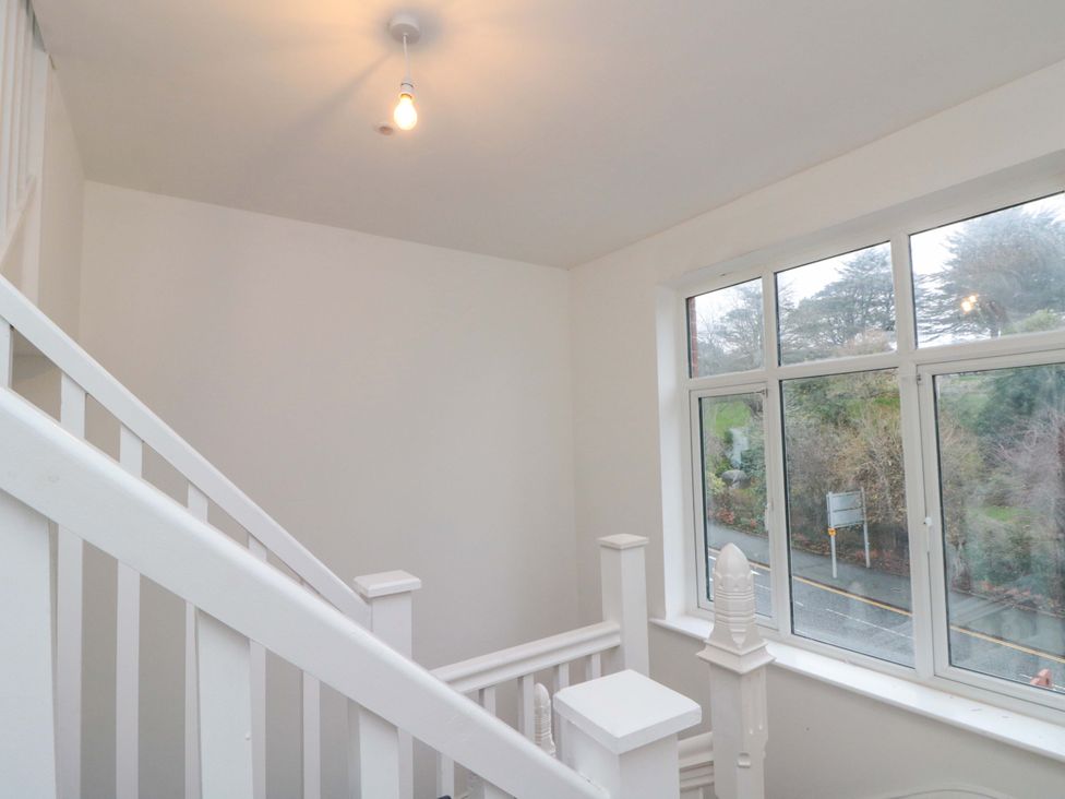 A staircase with a window and light fixture at Beachwalk Villa 2 in Whitby