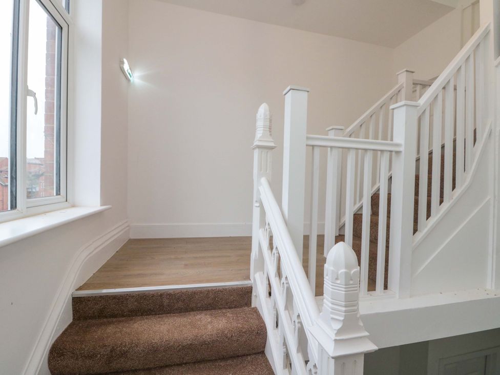 A staircase with a landing and windows at Beachwalk Villa 2 in Whitby