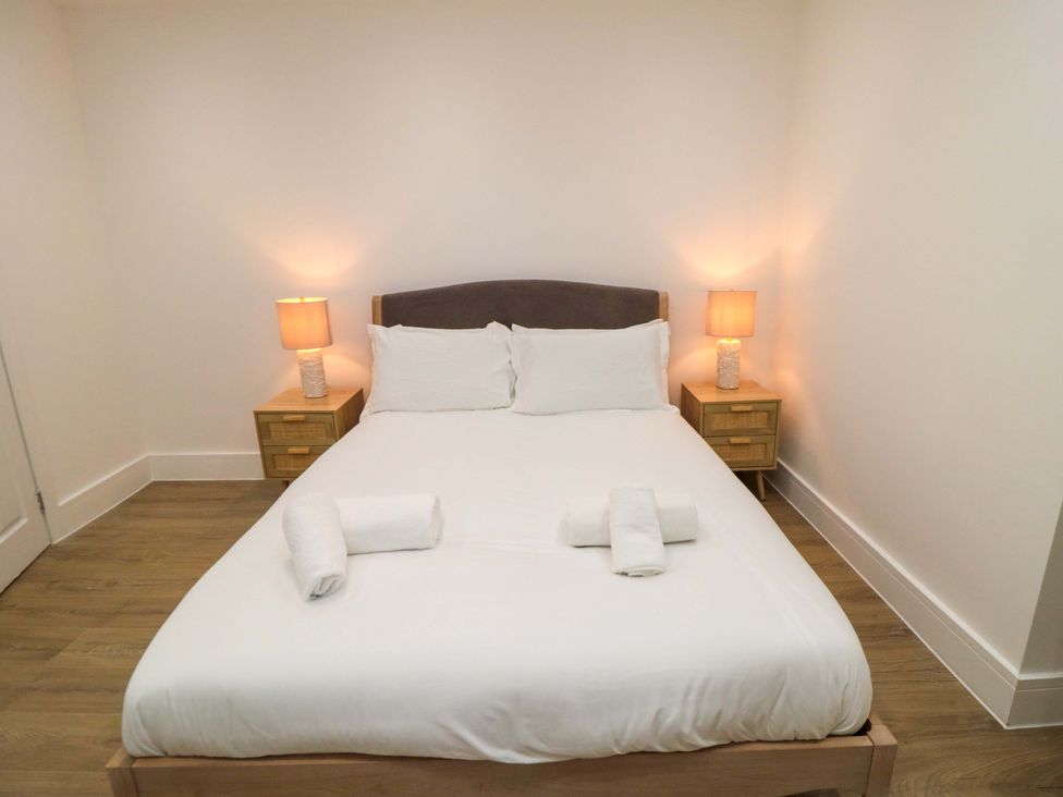 A bedroom with a bed and nightstands at Beachwalk Villa 2 in Whitby