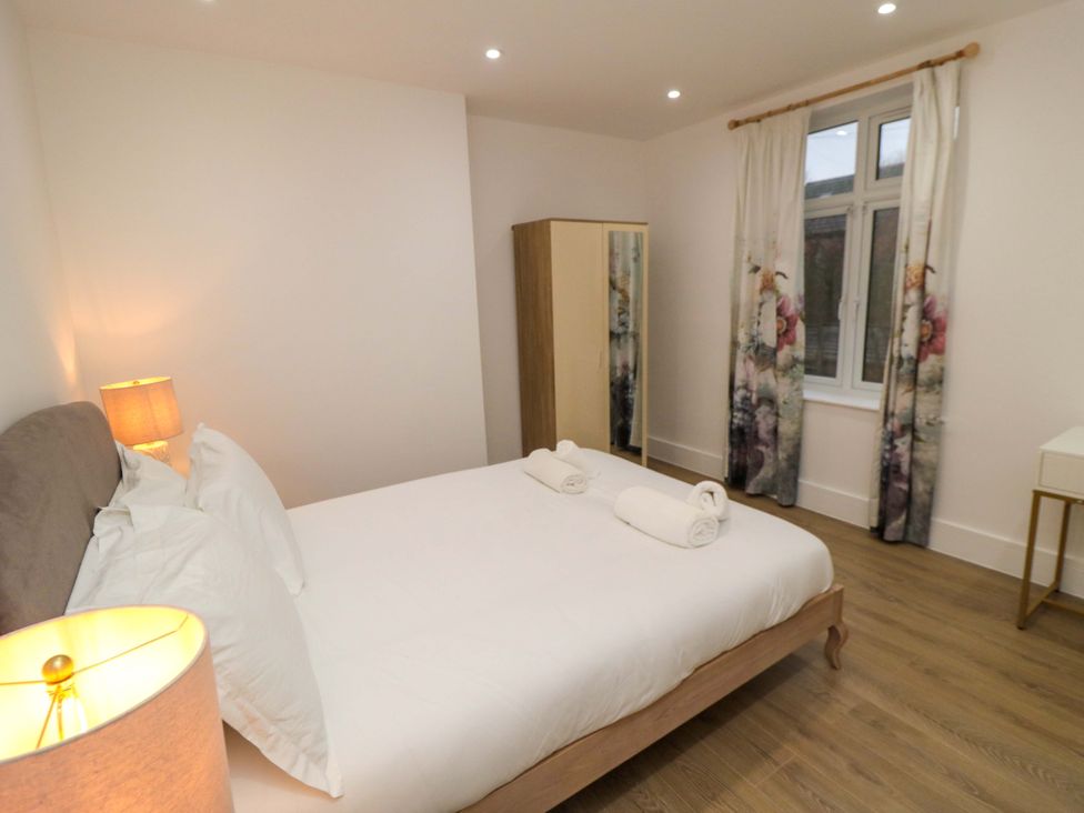 A bedroom with a bed and a wardrobe at Beachwalk Villa 2 in Whitby