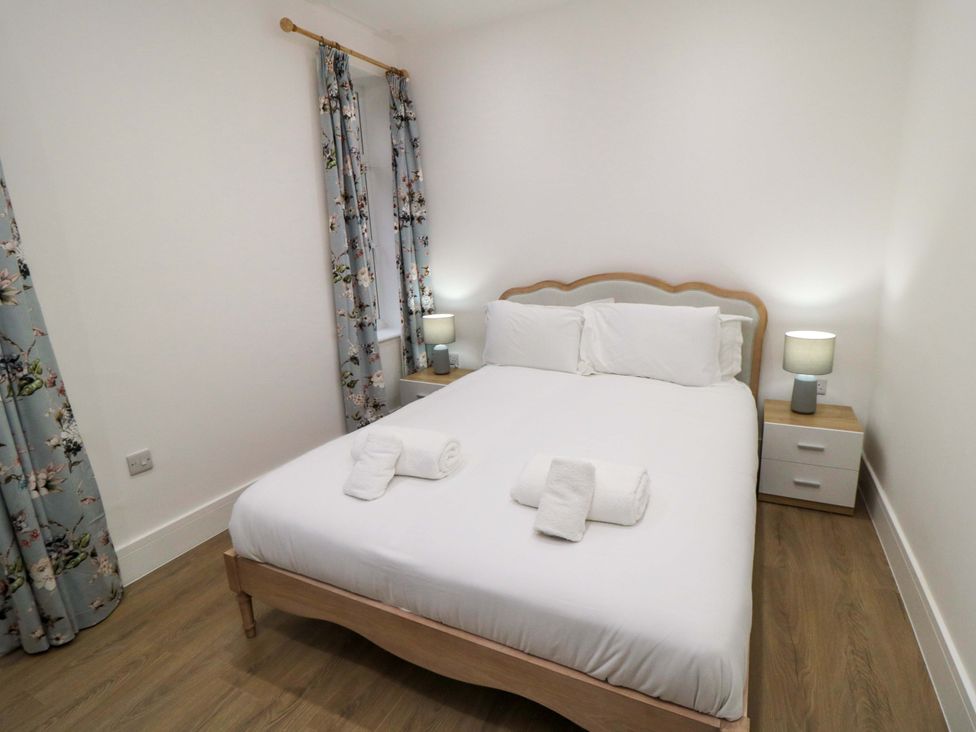 A bedroom with a bed and bedside tables at Beachwalk Villa 2 in Whitby