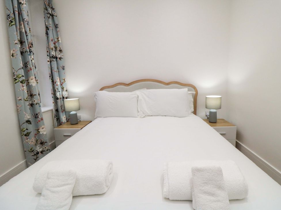A bedroom with a bed and lamps at Beachwalk Villa 2 in Whitby