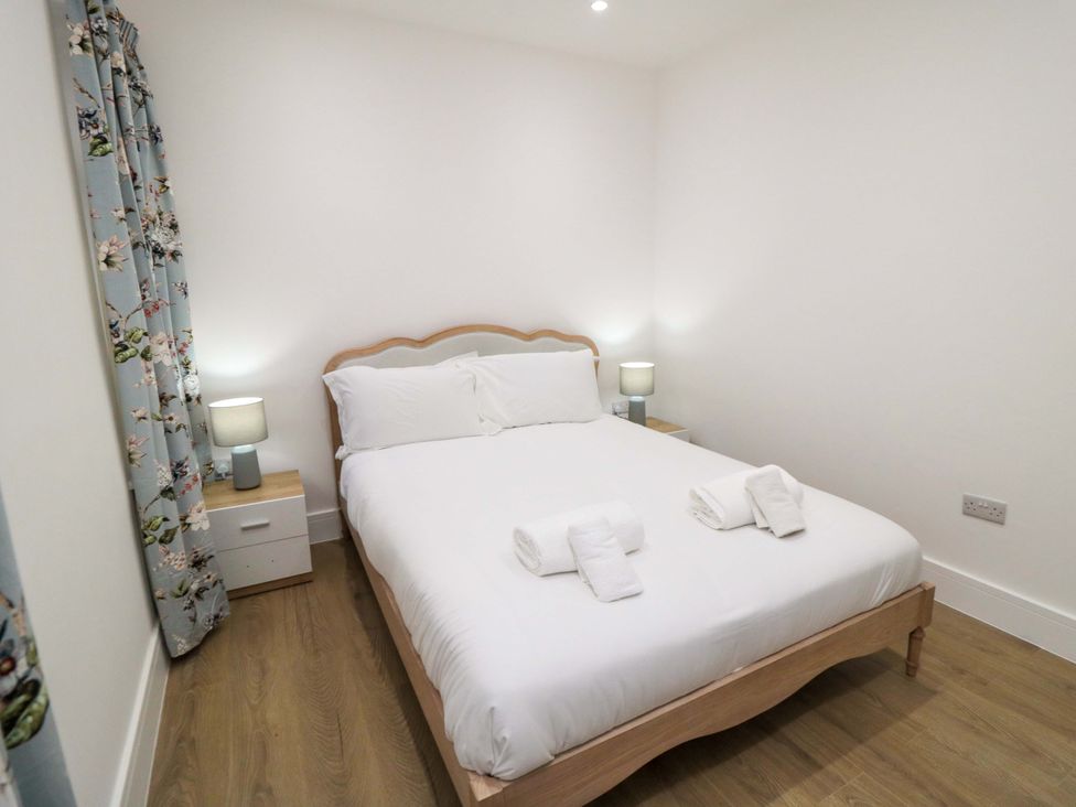 A bedroom with a bed and bedside table at Beachwalk Villa 2 in Whitby
