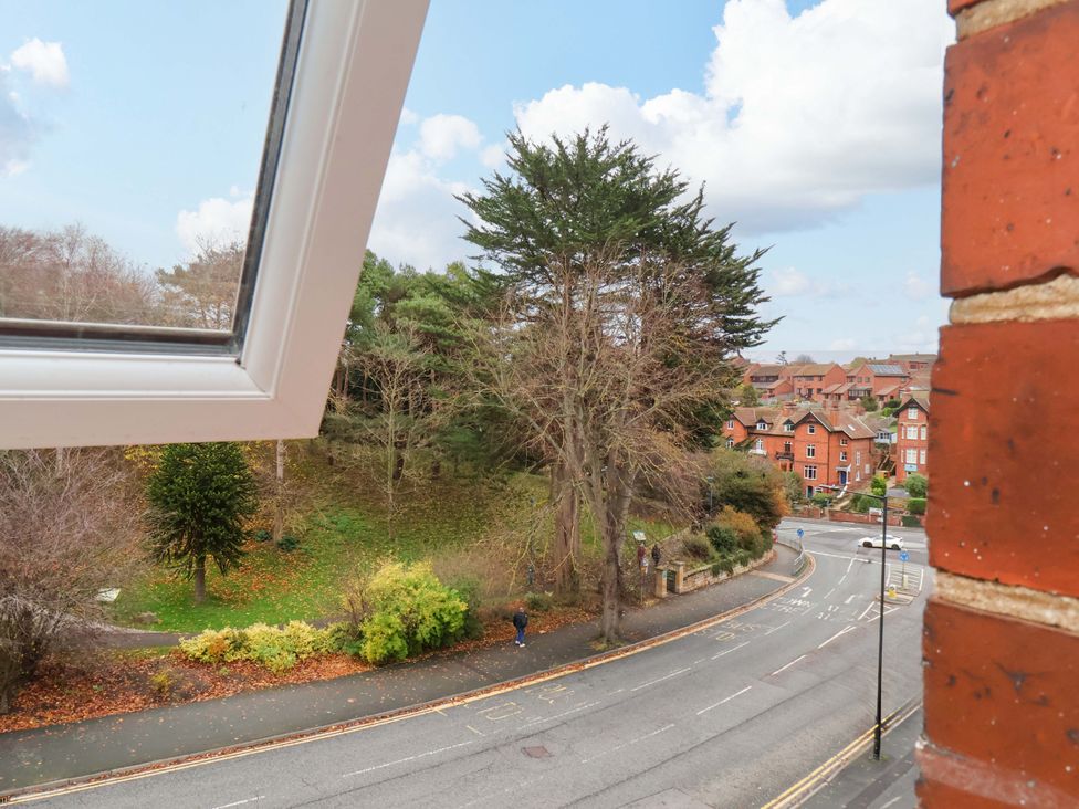 A view of trees and road from a window at Beachwalk Villa 3 in Whitby