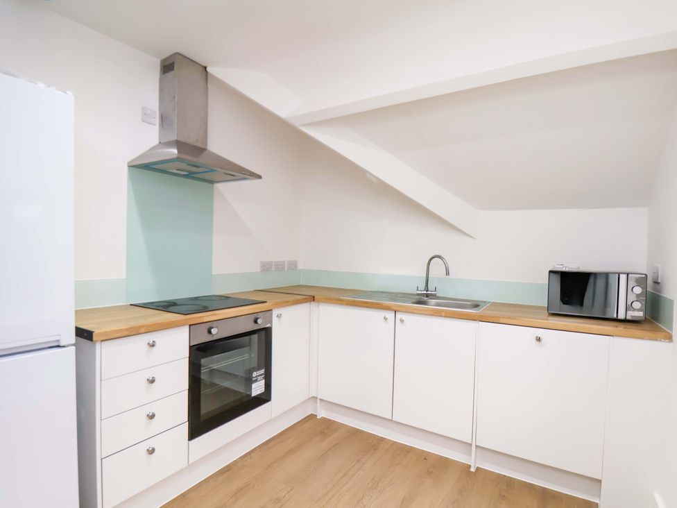 A kitchen with a sink and stove at Beachwalk Villa 3 in Whitby