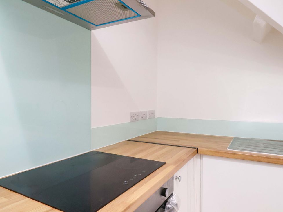 A kitchen with stovetop and sink at Beachwalk Villa 3 in Whitby