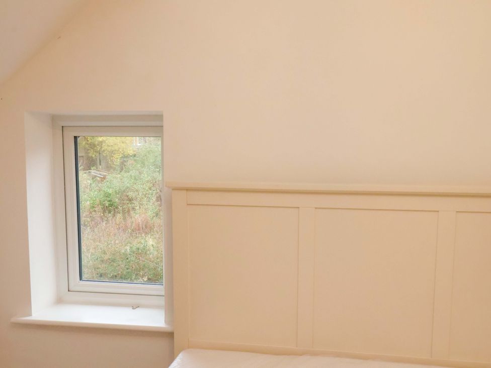 A bedroom with a window and bed headboard at Beachwalk Villa 3 in Whitby
