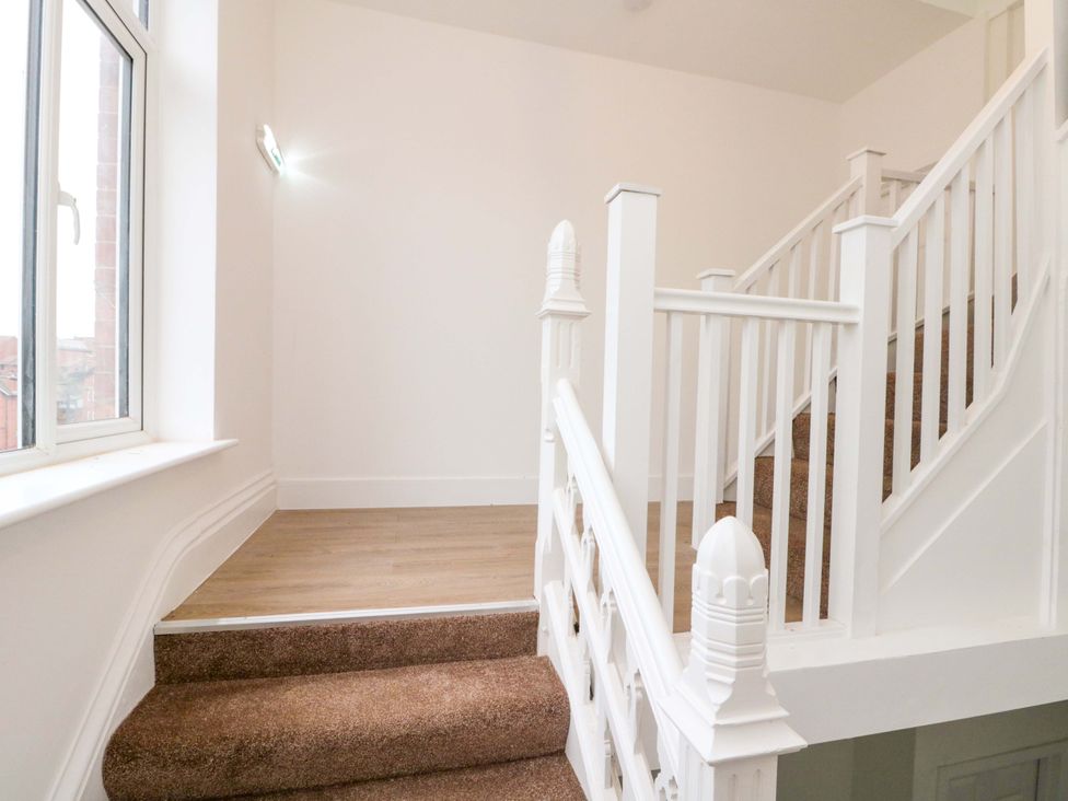 A staircase with handrail and window at Beachwalk Villa 3 in Whitby