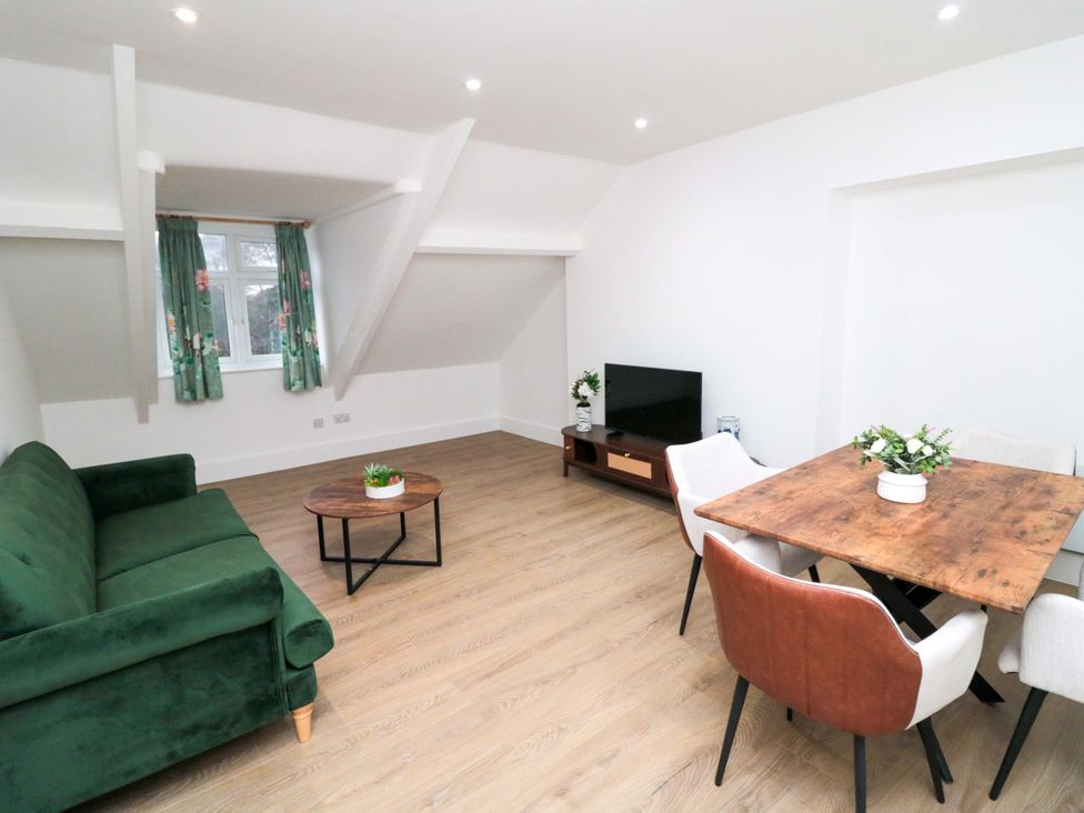 A living room with a sofa and a dining area at Beachwalk Villa 3 in Whitby