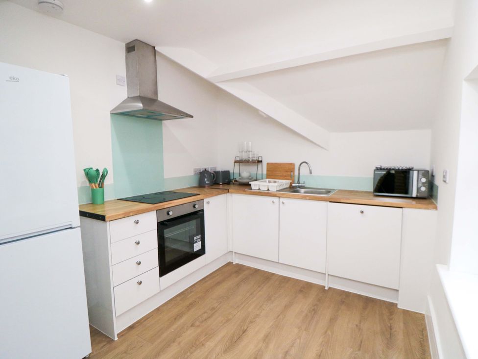 A kitchen with a refrigerator, oven, and sink at Beachwalk Villa 3 in Whitby