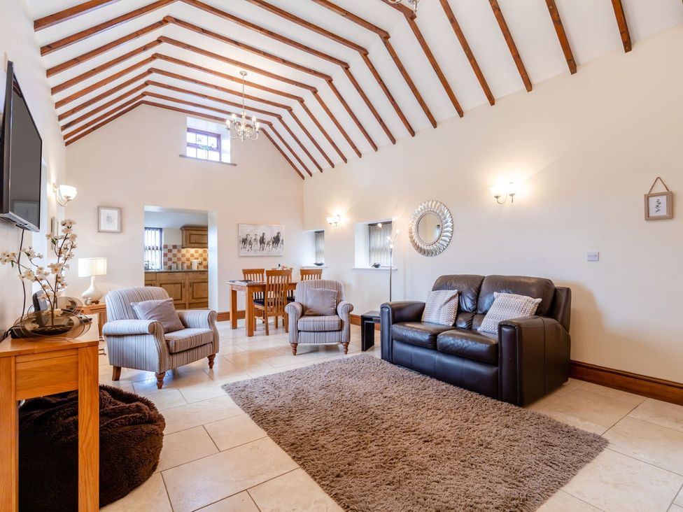 A living room with a sofa and chairs at Lanes Barn in Whitby