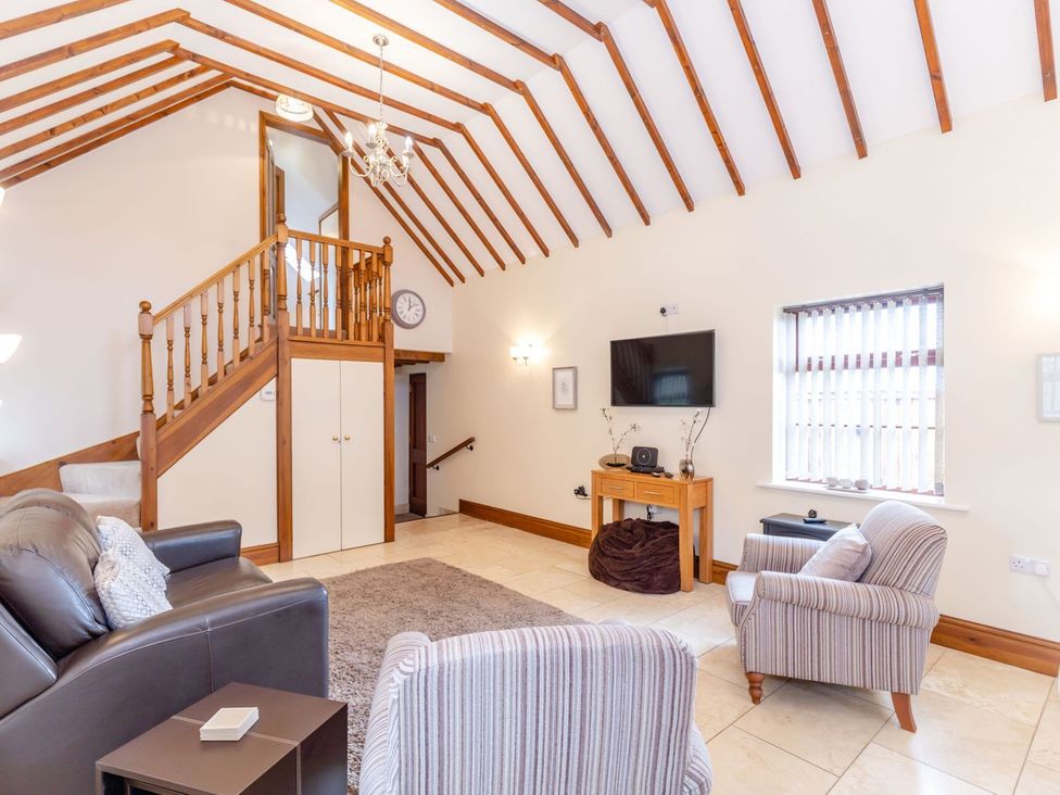 A living room with a staircase and furniture at Lanes Barn in Whitby