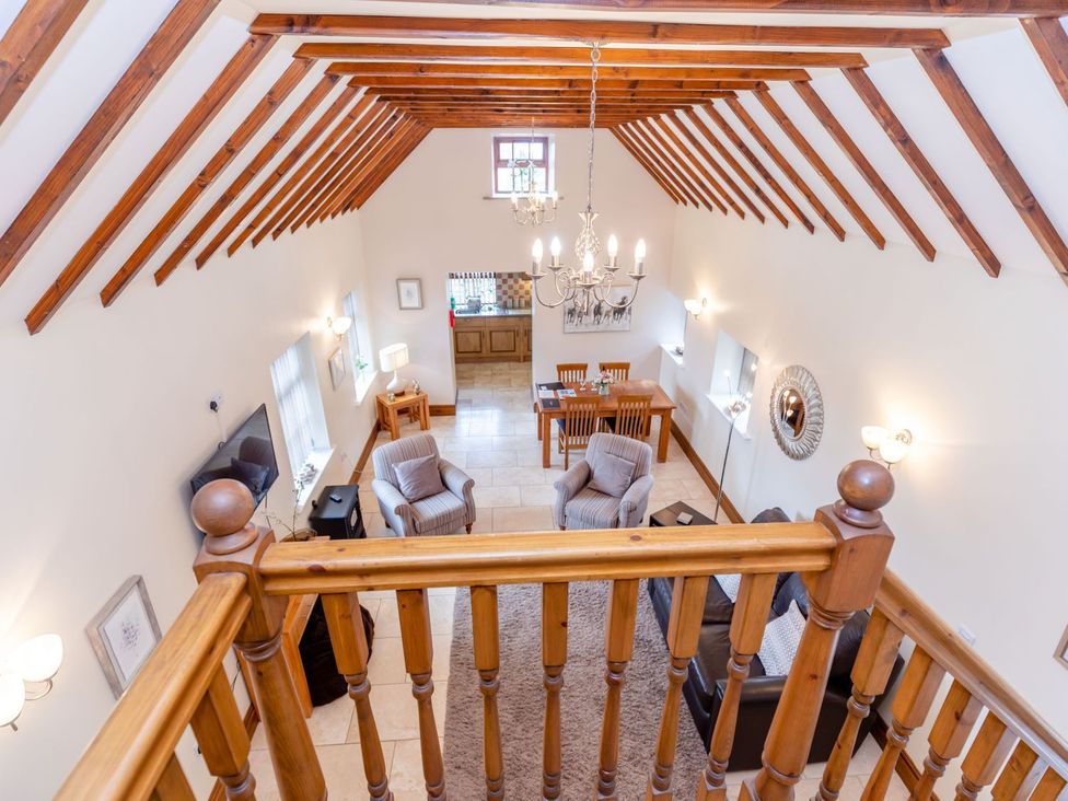 A living room with a dining area and chandelier at Lanes Barn in Whitby
