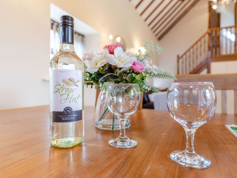 A dining room table with a wine bottle and glasses at Lanes Barn in Whitby