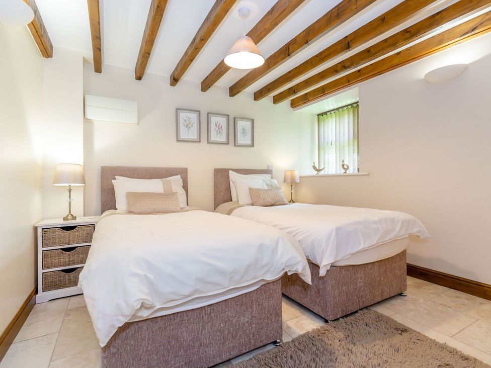 A bedroom with two beds and a lamp at Lanes Barn in Whitby