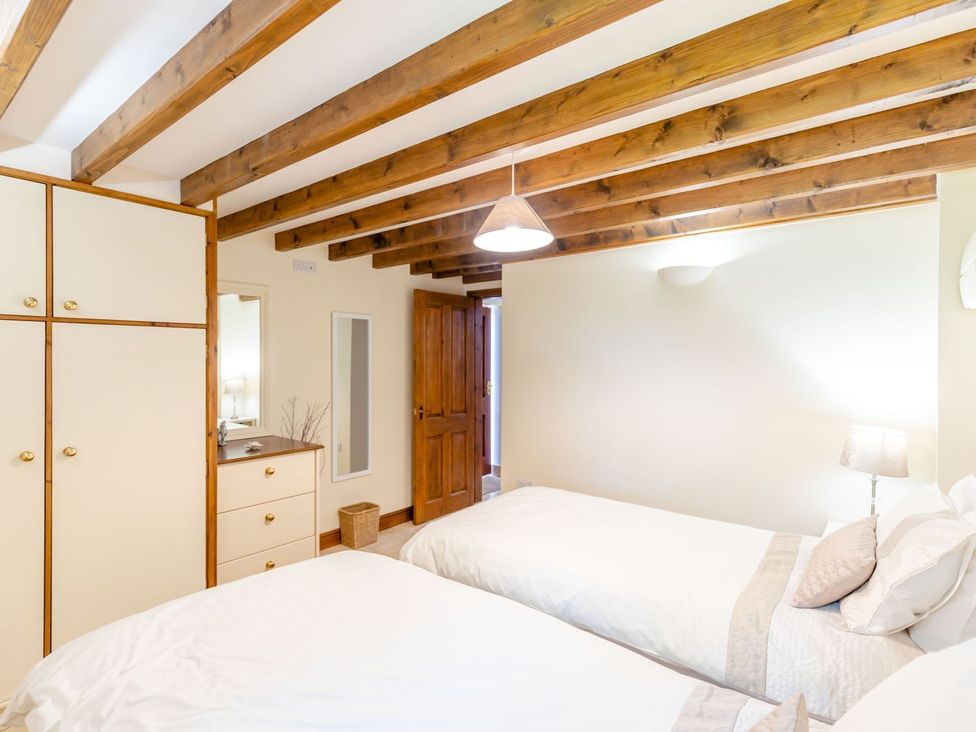 A bedroom with twin beds and mirrored wardrobe at Lanes Barn, Whitby
