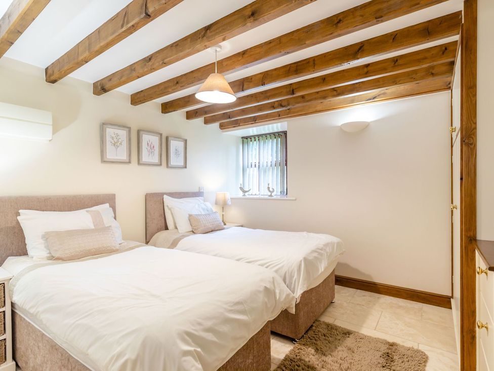 A bedroom with two beds and a lamp at Lanes Barn Whitby