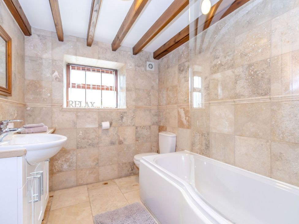 A bathroom with a bathtub and sink at Lanes Barn, Whitby