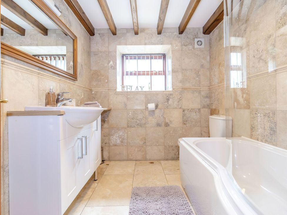 A bathroom with a sink, toilet, and bathtub at Lanes Barn in Whitby