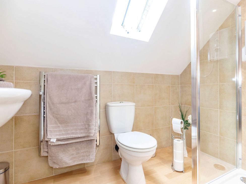 A bathroom with a shower and towels in Lanes Barn Whitby