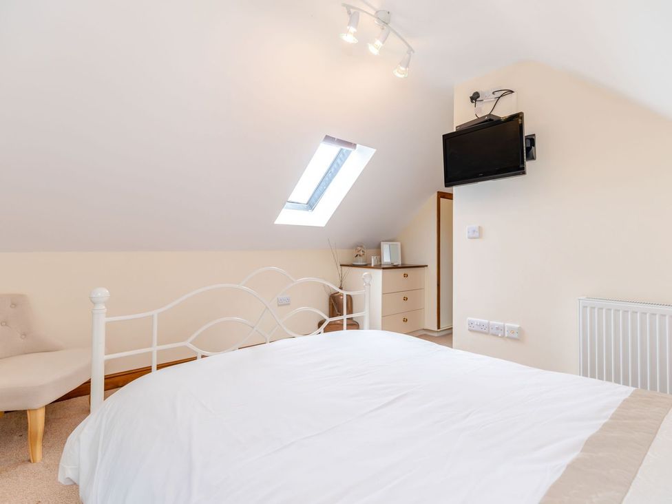 A bedroom with a bed and television at Lanes Barn in Whitby