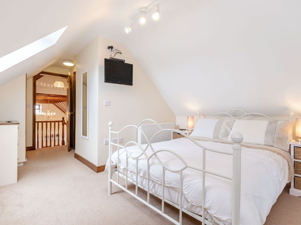 A bedroom with a bed and a television at Lanes Barn in Whitby