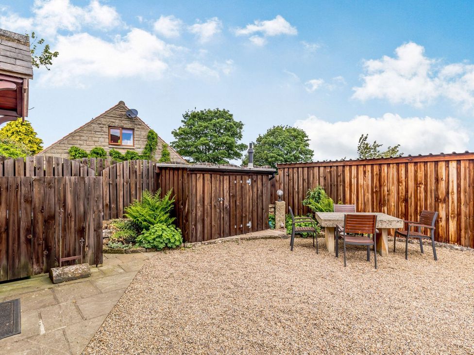 A garden with a table and chairs at Lanes Barn in Whitby